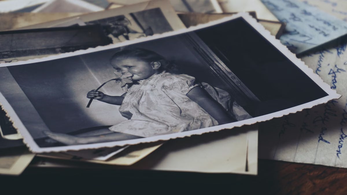 A nostalgic black and white photo of a child with old letters, evoking memories.